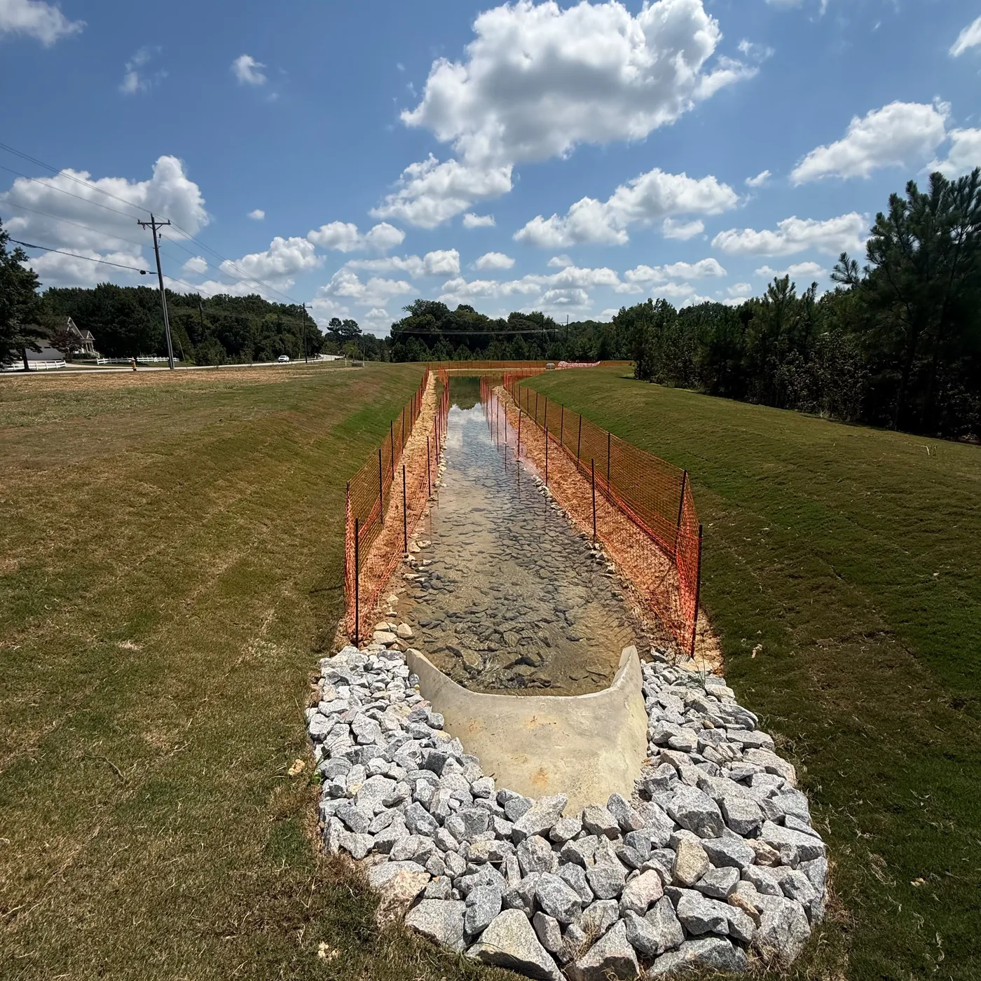 Completed stone-lined stormwater channel and spillway by Delcid in North Carolina