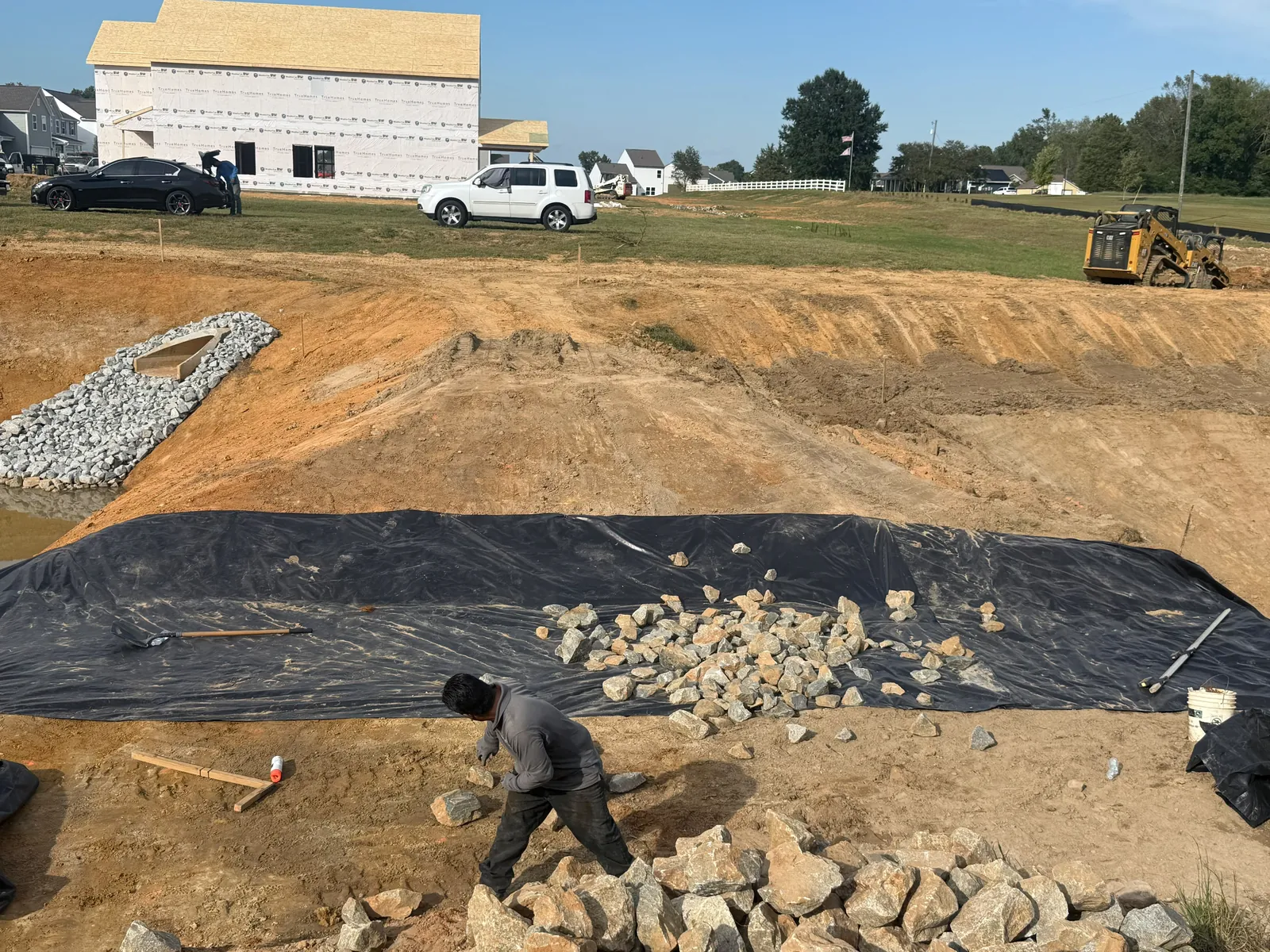 Crew placing stone over geotextile at Nathans Ridge Pond 1