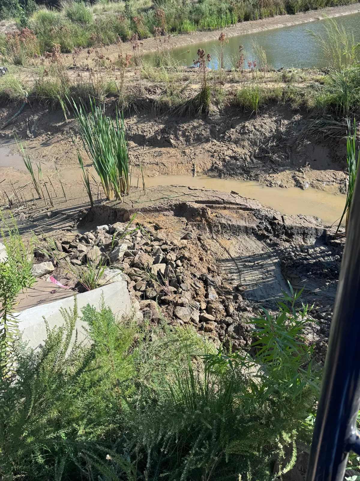 Placing rip-rap in a stormwater channel at Nathans Ridge Pond