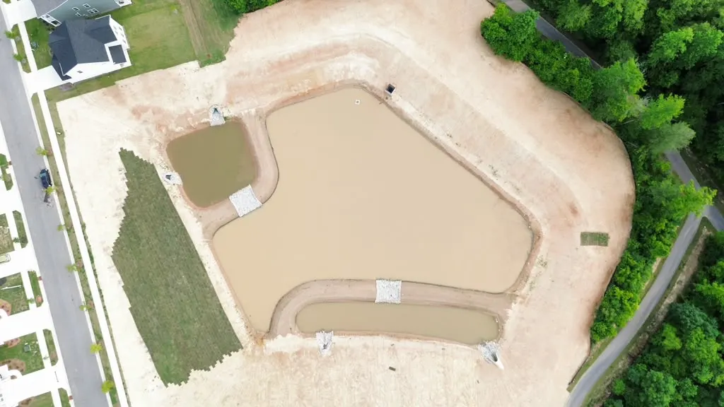 Aerial view of an unfinished stormwater pond before Delcid's pond conversion work